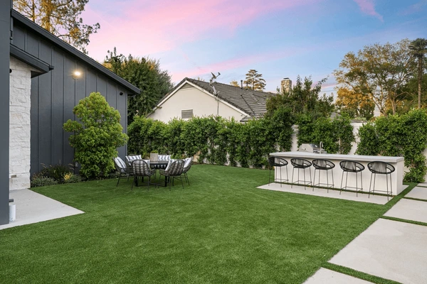 Contemporary patio design featuring artificial grass and pavers